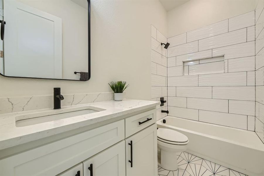 Full bathroom featuring tile patterned floors,  shower combination, vanity, and toilet