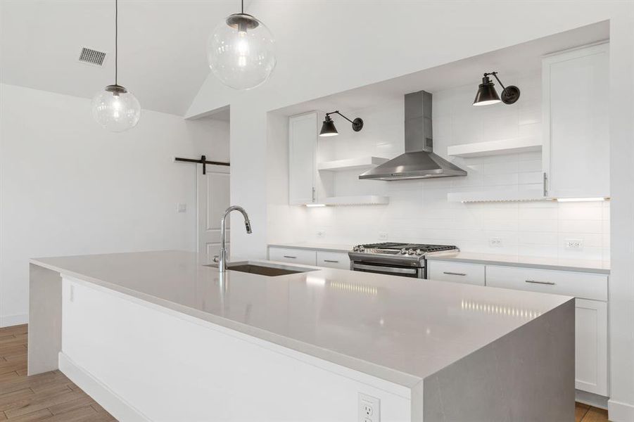 Stainless vent hood, subway tile, shelving, accent lights and under cabinet lights make this wall a statement. Barndoor leads to flex room that can be used for dining, office, game room to what ever fits you best.