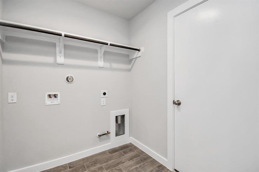 Capture the essence of easy living with a laundry room, thoughtfully equipped with shelving for effortless organization. Both electric and gas connections available. Sample photo of completed home. As-built color and selections may vary.