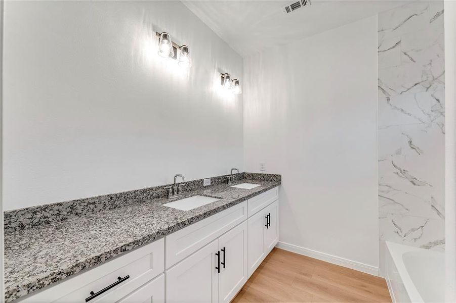 The master bathroom showcases a double vanity with ample counter space, promising a luxurious and functional experience for two.