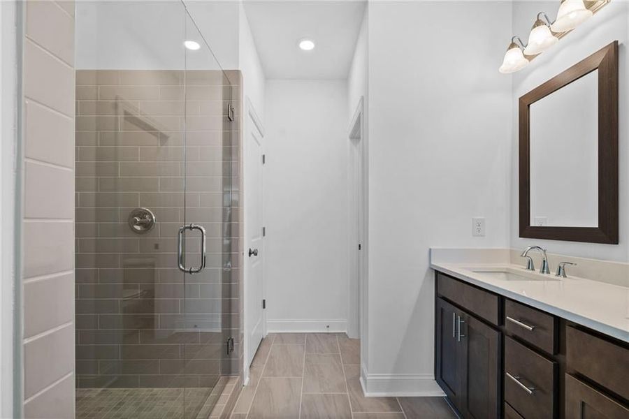 Primary Bathroom with dual vanities and a Massive Walk in shower with Dry off Area - This picture represents a previously built home