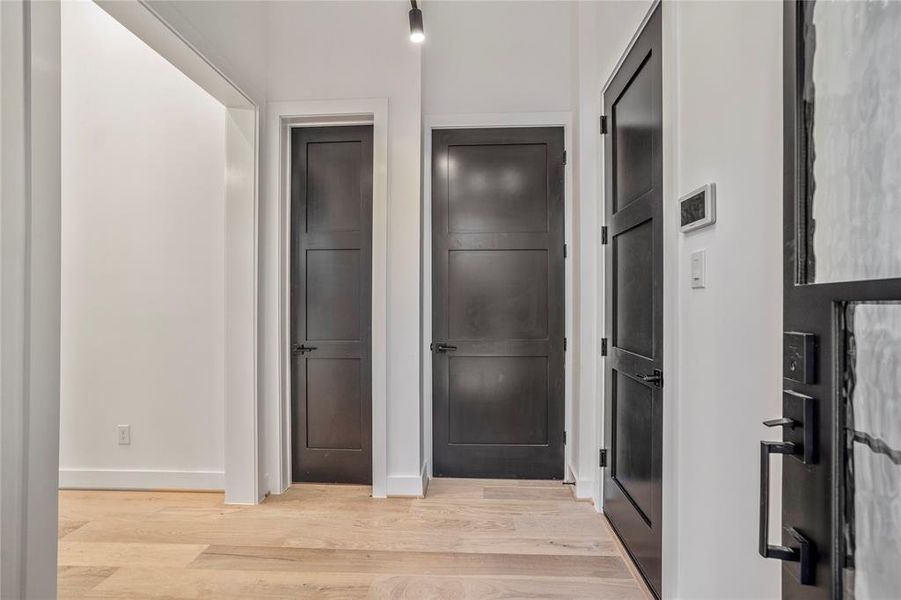 Stunning white oak hardwoods throughout this home. Door to the right leads to the garage. Closed door straight ahead is the elevator capable closet that is now a huge walk-in storage closet. Smaller door to the left in this picture is your powder bath.