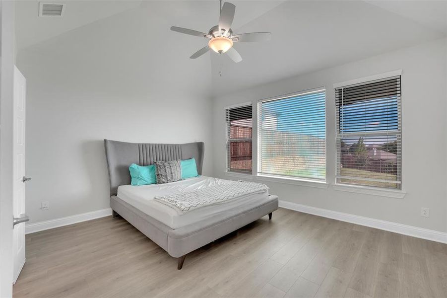 Bedroom featuring lofted ceiling, light hardwood / wood-style floors, and ceiling fan