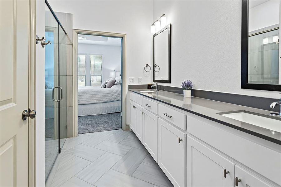 Bathroom featuring a shower with shower door and vanity