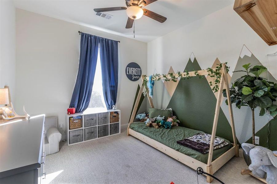 Carpeted bedroom featuring ceiling fan