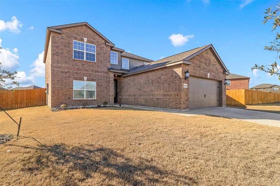 View of front of property featuring a garage and a front lawn