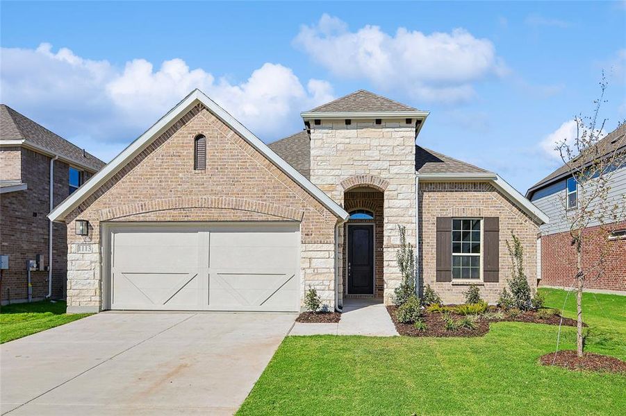 View of front of house featuring a front lawn and a garage