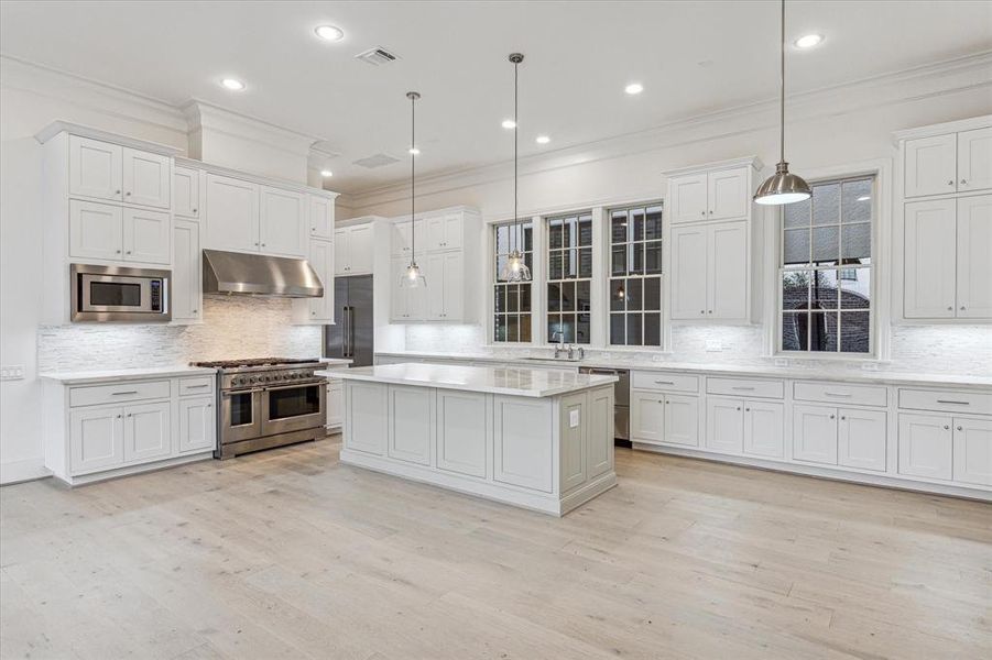 Spacious island kitchen with quarz counters and stainless steel Fisher & Paykel appliances