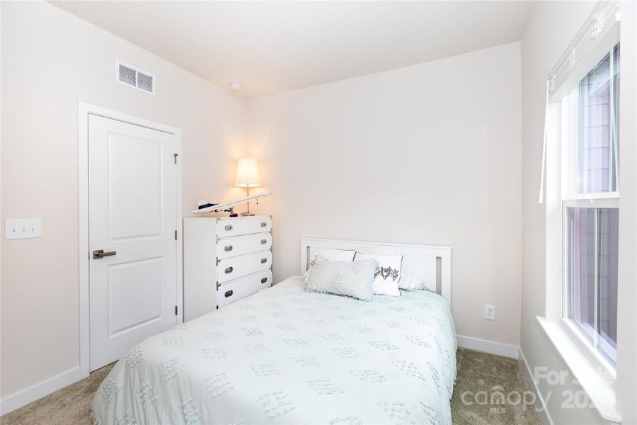 Second bedroom with ensuite bath, lots of natural light, and large closet.