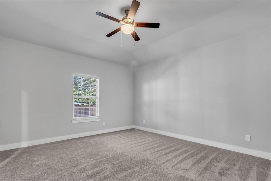 Carpeted empty room with ceiling fan