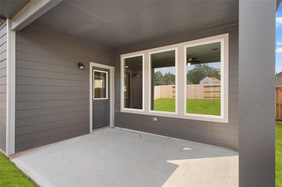 The covered patio is generously sized, providing ample space for various outdoor activities.