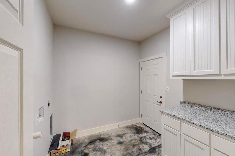 Washroom featuring cabinets and hookup for an electric dryer