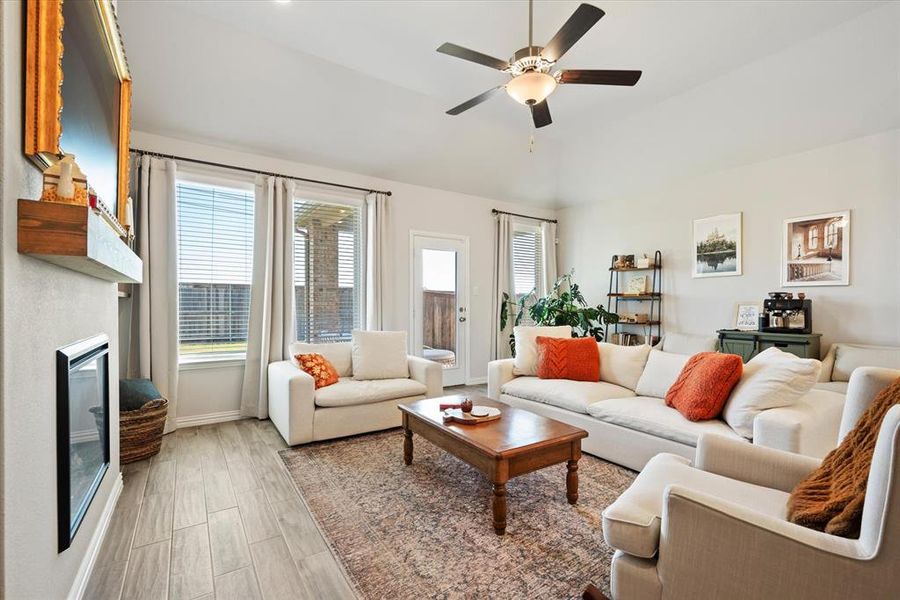 Living room with wood tile flooring, ceiling fan and electric fireplace