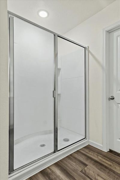 Bathroom featuring hardwood / wood-style floors and an enclosed shower