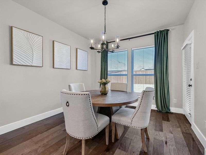 Dining space with a notable chandelier and dark hardwood / wood-style floors