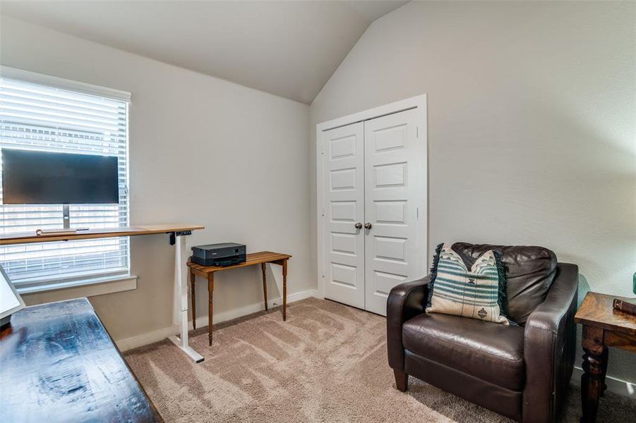 Living area featuring vaulted ceiling and light colored carpet