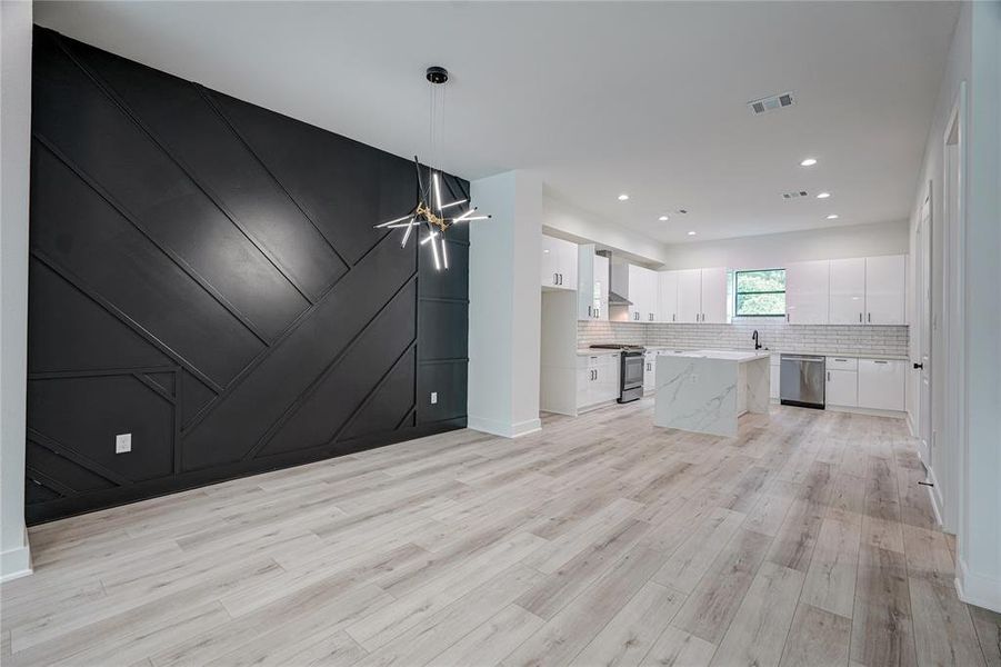 Dining room with accent wall and designer lighting