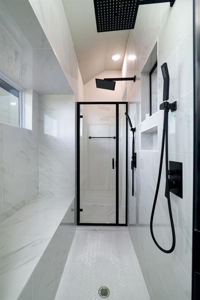 Bathroom with tiled shower, tile floors, and lofted ceiling