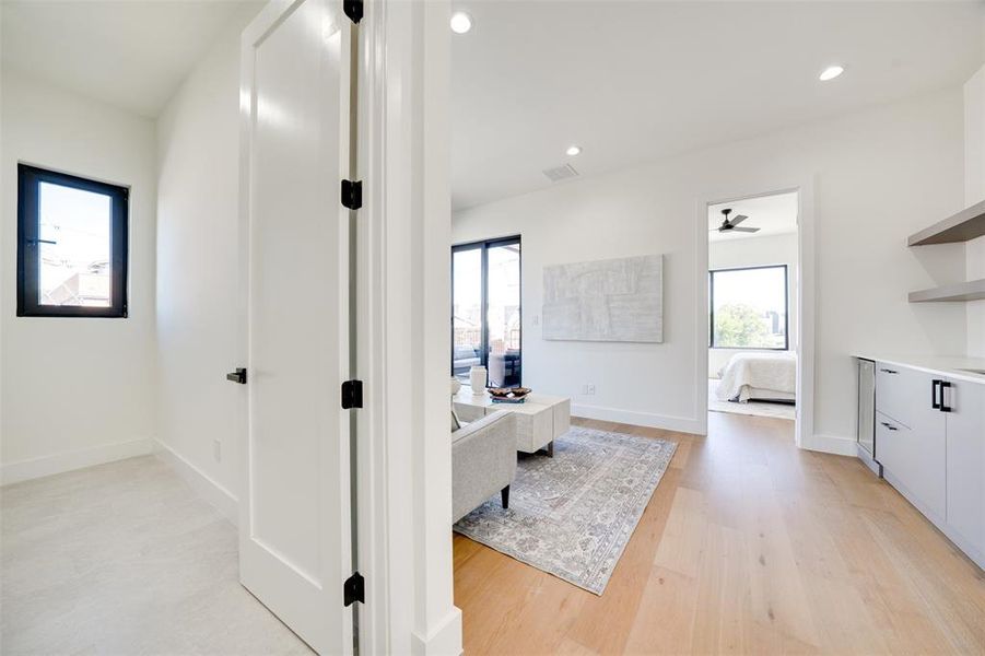 Hall with light hardwood / wood-style flooring and plenty of natural light