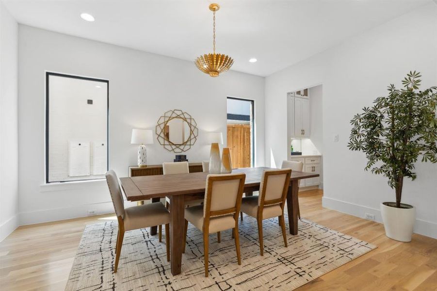 Dining area with light hardwood and light fixture