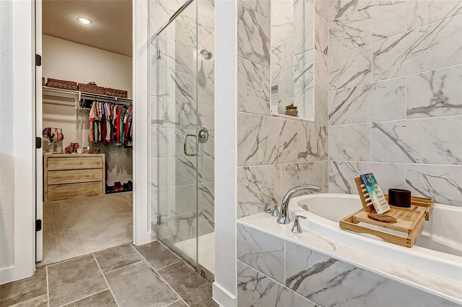 The separate shower and tub area offer floor to ceiling luxurious tiles with elegant Shluter trim and seamless glass doors for a spa quality expierence.