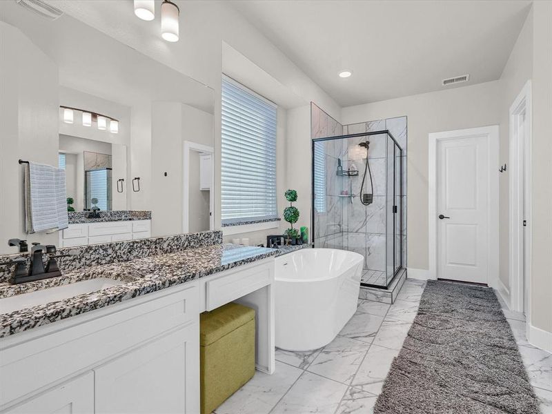 Bathroom featuring vanity and shower with separate bathtub