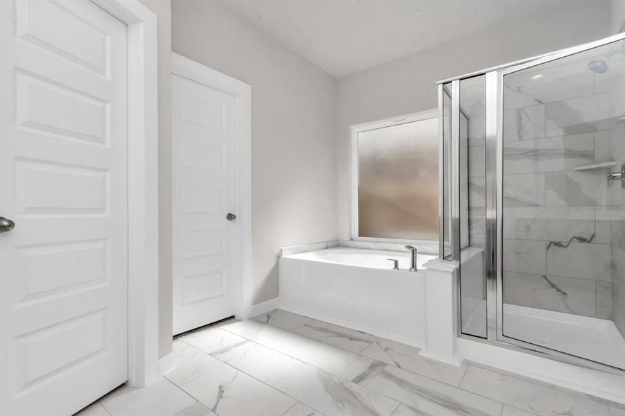 The primary en-suite has a soaking tub to give you that spa experience. The large privacy window allow lots of nature light in the space. Sample photo of completed home with similar floor plan. As built color and selections may vary.