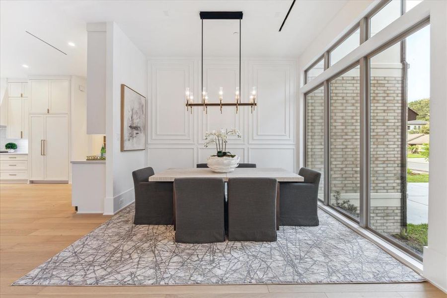 DINING ROOM: Bathed in natural light from a vast expanse of floor-to-ceiling windows, this space is a symphony of elegance and sophistication, offering an unparalleled dining experience.