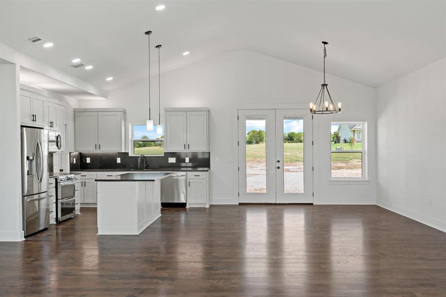 Kitchen featuring backsplash, pendant lighting, dark hardwood / wood-style floors, and stainless steel appliances