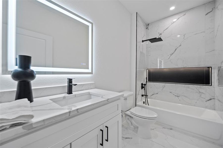 Full bathroom with tiled shower / bath, vanity, and toilet