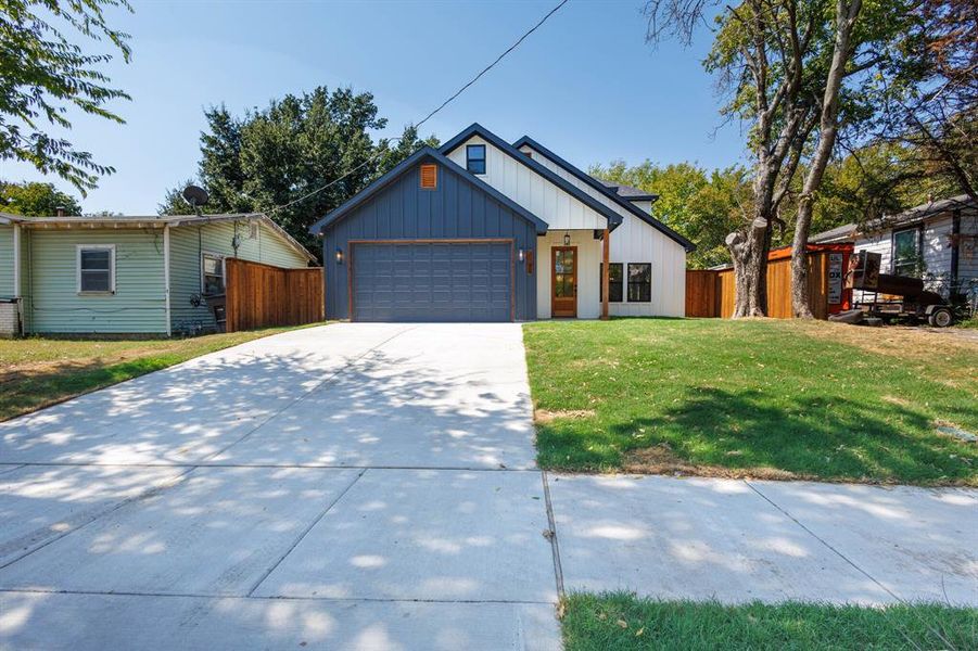 View of front of house with a front yard and a garage