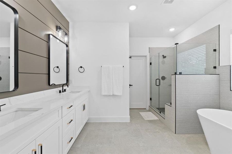 Primary bath with double sinks, soaking tub and walk-in shower with bench seating. Priv ate water closet.