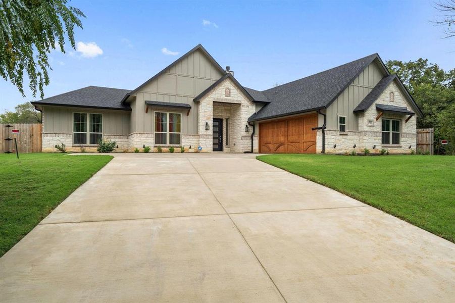 View of front of home with a front yard and a garage