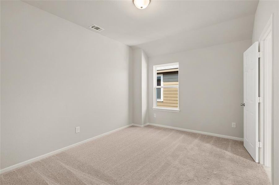 Your secondary bedroom features plush carpet, fresh paint, closet, and a large window that lets in plenty of natural lighting.