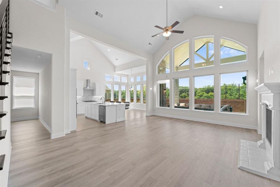 Unfurnished living room with a wealth of natural light and high vaulted ceiling