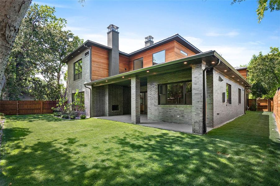 Rear view of house with a lawn and a patio