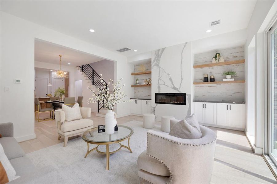 The stunning fireplace feature is framed by open white oak shelving and quartz topped cabinetry.