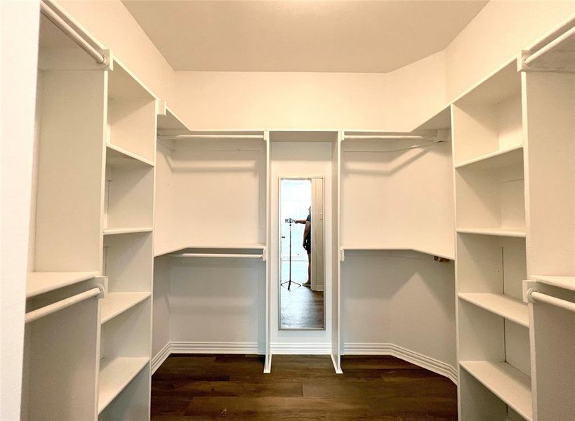 Master Bedroom Spacious walk - in closet featuring dark hardwood / wood-style floors