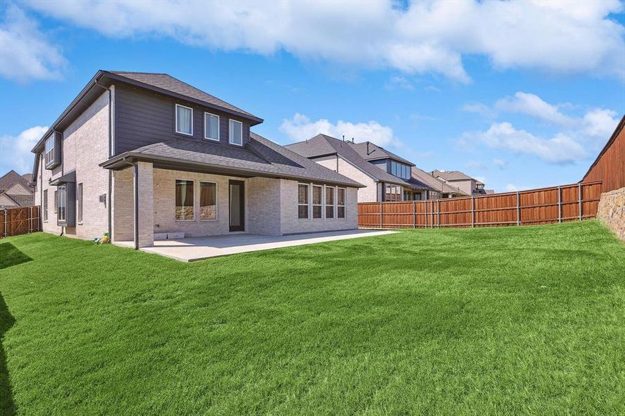 Rear view of house featuring a yard and a patio area