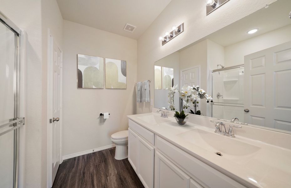 Modern owner's bath with dual vanities and a spaci