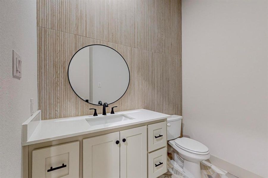 Bathroom with vanity, tile walls, and toilet