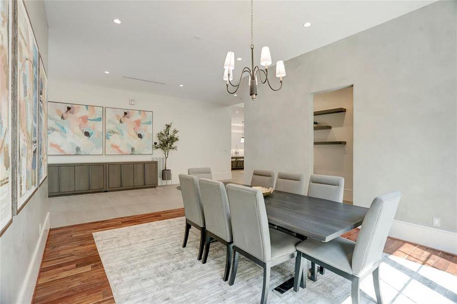 The Dining Room features Venetian plaster walls, Brazilian Walnut flooring, a beautiful black and brass chandelier, recessed LED lights, linear AC vents and a wall of large windows.