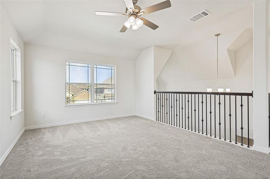 Unfurnished room with ceiling fan, carpet, and vaulted ceiling