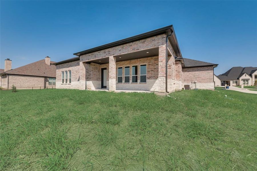 Rear view of house with a yard and a patio area