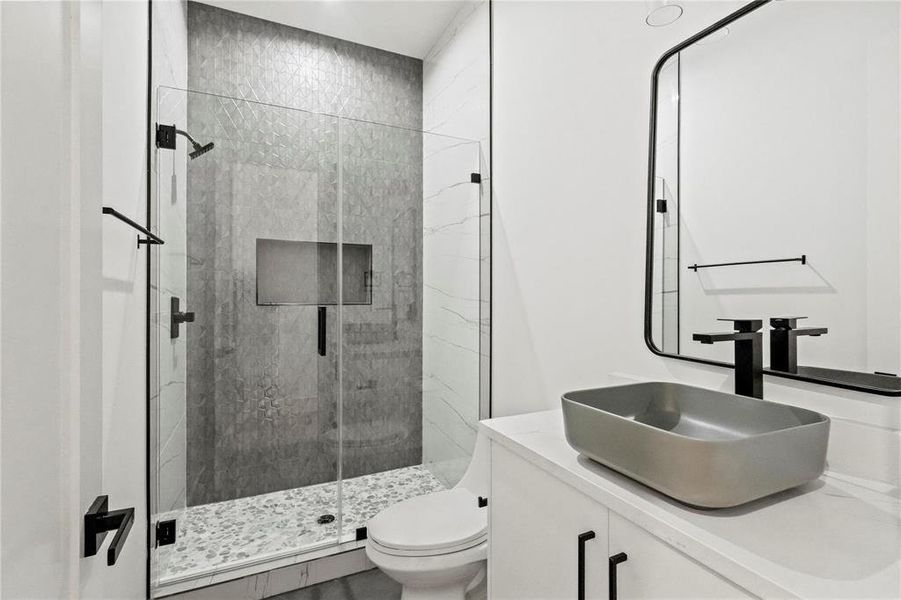 Bathroom featuring vanity, toilet, and walk in shower