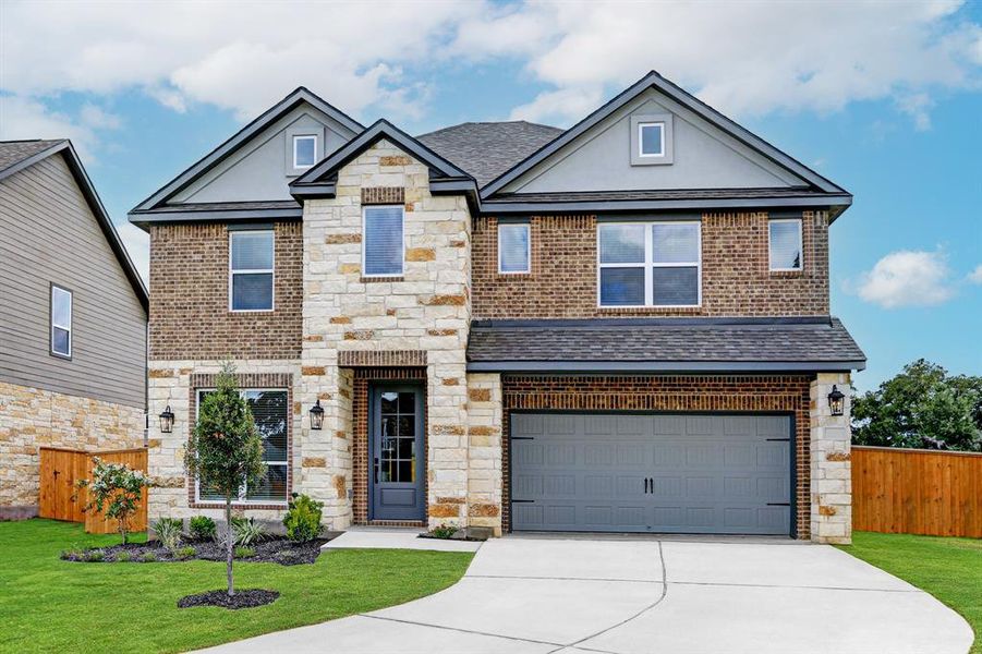 Gorgeous blend of brick, stone, and stucco exterior with wood siding.