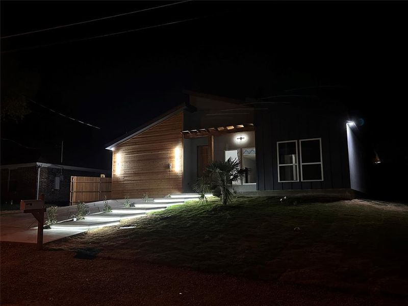 Back house at night featuring a patio area