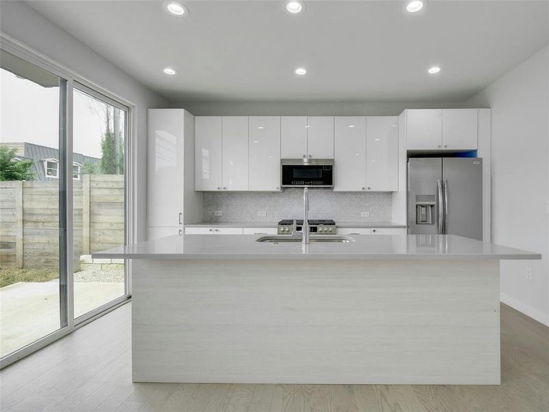 The gourmet kitchen is equipped with a center island, breakfast bar, quartz countertops, and stainless-steel appliances, making meal preparation a joy.