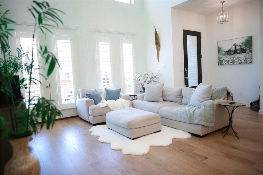 Living room featuring light wood-type flooring and a chandelier