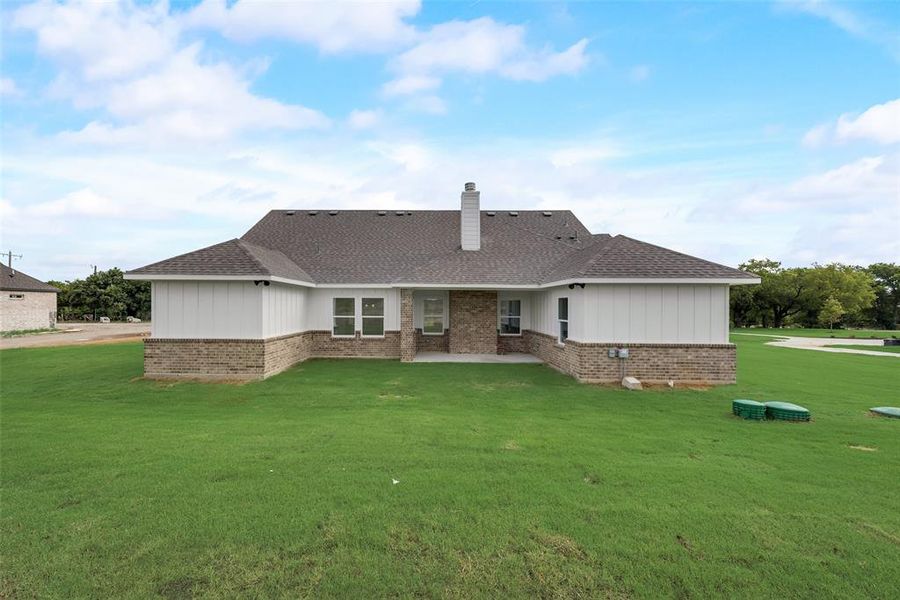 Back of house featuring a lawn